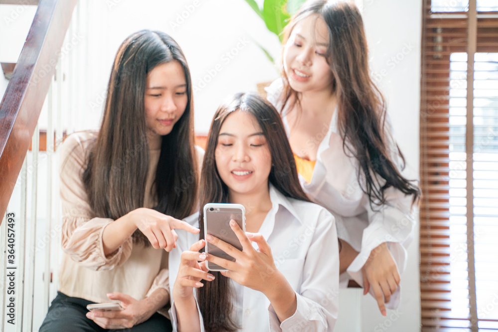 Wall mural group of female friends in home office using digital smartphone devices looking together