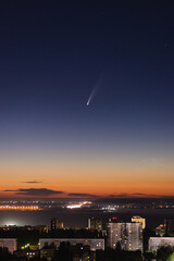 Comet at night over the city at dawn. The brightest comet in the last few years.