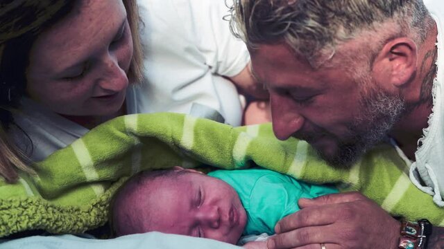 Newborn baby kissed by the parents in the city park