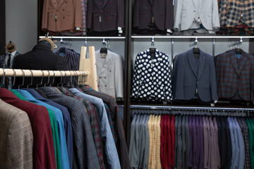 expensive men's clothing store. a row of jackets on hangers. shoping sale background theme. clothes...