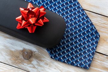 Father's Day Concept. Gift Box with Tie on wooden background. Copy space for text.