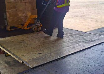Worker unloading shipment carton boxes and goods on wooden pallet by forklift  from container truck to warehouse cargo storage in logistics and transportation industrial 