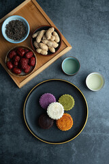 Colorful moon cakes are placed on black plates. Chinese traditional food mid autumn moon cake