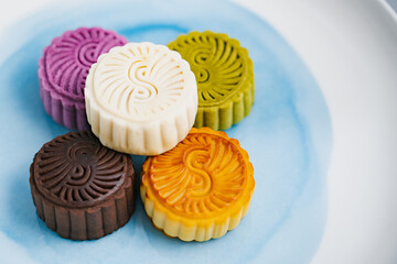 Colorful moon cakes are placed on white plates. Chinese traditional food mid autumn moon cake