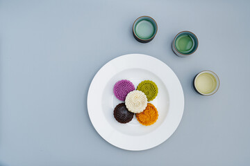 Colorful moon cakes are placed on white plates. Chinese traditional food mid autumn moon cake