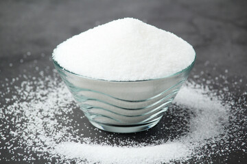 A glass bowl with white sugar