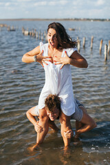 A man under a woman's skirt. The man got under the woman's skirt. A man looks between a woman's legs. The man is fooling around.