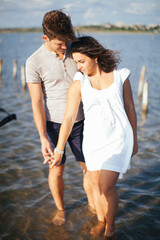 A couple in love on the beach. A man and a woman kiss. A couple in love walking on the beach. Date on the beach. Love.