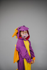 beautiful young girl with nose and mouth mask dressed in dragon costume during corona crisis
