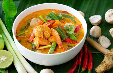 Tom yum koong in white dish and ingredient on wooden background