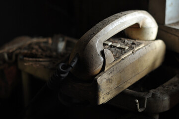 Close up of old damaged telephone on the abandoned deserted house