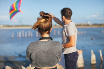 Fototapeta premium Friends play with a kite. A couple in love launches a kite. A guy and a girl look at a kite in the sky.