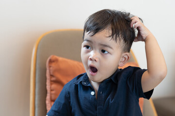 Asian cute baby boy yawning on sofa background.