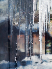 Icicles which are hanging down from a roof, beautiful background blur, selective soft focus