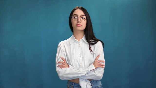 Casual mixed race female in trendy glasses posing with crossed hands. Medium shot on RED camera