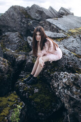 Young brunette girl portrait outdoors in grey mountains outdoors. Woman beauty concept