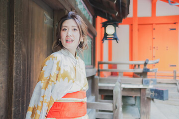 神社の境内で休憩する浴衣姿の女性
