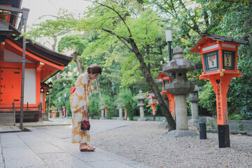 神社の境内を散歩する浴衣姿の女性