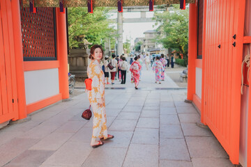 神社の境内でこちらを振り返る浴衣姿の女性