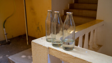 Fototapeta na wymiar Empty glass bottles are on the balcony railing.