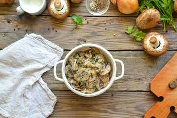 Royal champignons in sour cream sauce. Recipe. Step by step cooking mushrooms with onions. Wood background. Top view. Mushrooms with onions and sauce in a white bowl.