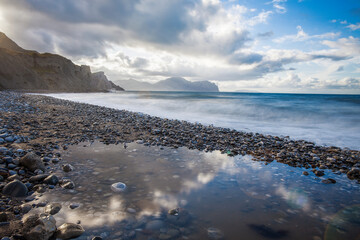 Ocean, clouds and rocky mountains
