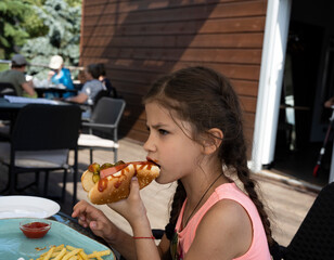 beautiful girl sits in a cafe and eats at the table