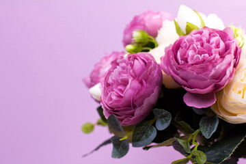 artificial  lilac and white peonies on a lilac background