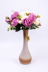white and purple peonies in a vase on a gray background