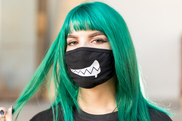 frau mit grünen haaren trägt eine schutzmaske - obrazy, fototapety, plakaty