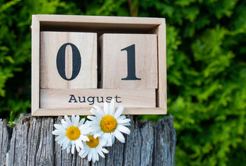 wooden block of the calendar is present 1 and the month of August amid the greenery of about three...
