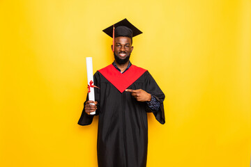 African American man college graduate pointed on diploma isolated on yellow background