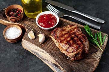 
Grilled beef steak with spices served on a cutting board on a stone background