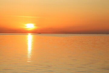 Golden sunset over the sea. Beautiful orange and yellow colors in calm water.