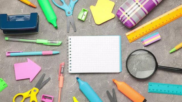 Stop motion of school stationery on grey concrete background. Shot in 4k resolution. Top view