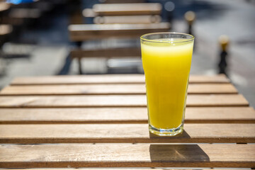 Closeup one glass with lemonade on wooden table. Selective focus