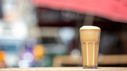 Closeup one glass with frappe on wooden table. Selective focus