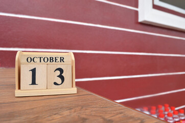 October 13, Number cube with wooden table beside the wall.