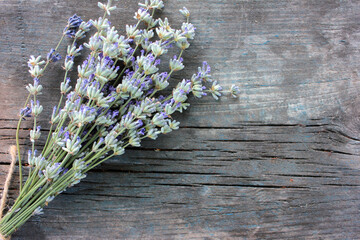 Bunch of lavender flowers on gray weathered wooden background. Close-up, top view, selective focus
