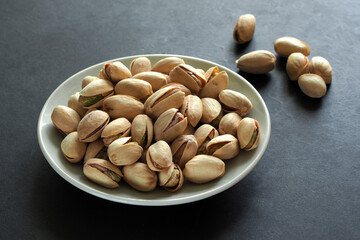 Pistachio nuts on a black surface.