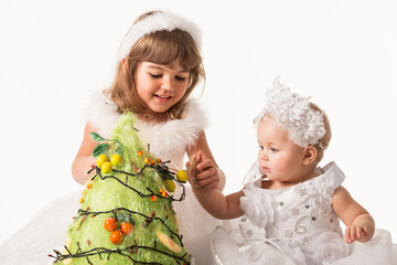 Adorable babies decorating christmas tree.