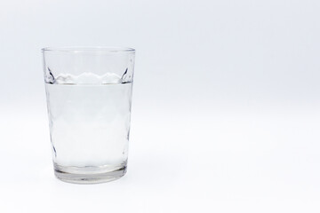 Transparent glass glass with water on a white background