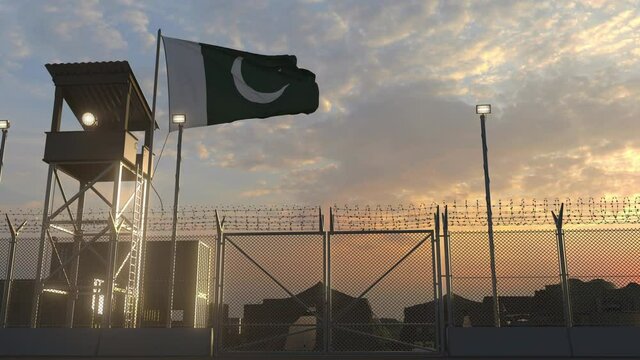 National flag of Pakistan above military base at sunset