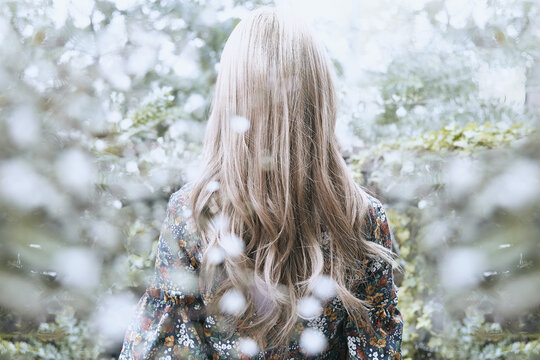 花柄のワンピースの巻き髪の女性の後ろ姿と植物のフォトジェニックな写真