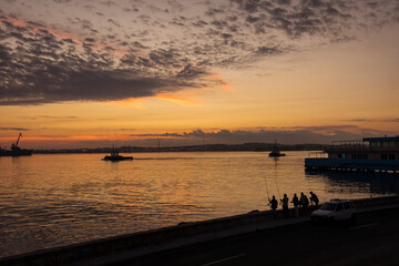 People fishing on Malecon street at sunrise in Havana, Cuba