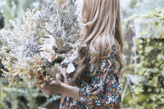 花柄のワンピースの巻き髪の女性と植物のフォトジェニックな写真