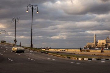 Old car on Malecon street of Havana with storm clouds in background. Cuba