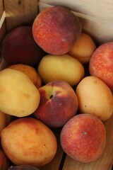 Ripe peaches and apricots in a wooden box