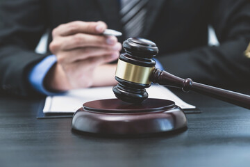 Judges gavel standing in front of the male lawyer is providing service to consult business dispute