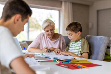 Fototapeta na wymiar Mother helping her kids doing homework at home 